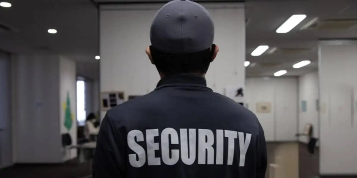 A man in a security uniform is standing in a home office of a security company.