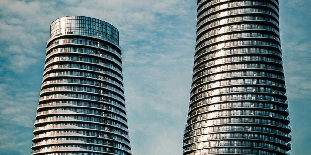 Two tall buildings stand next to each other, providing ample space for home security in apartments.