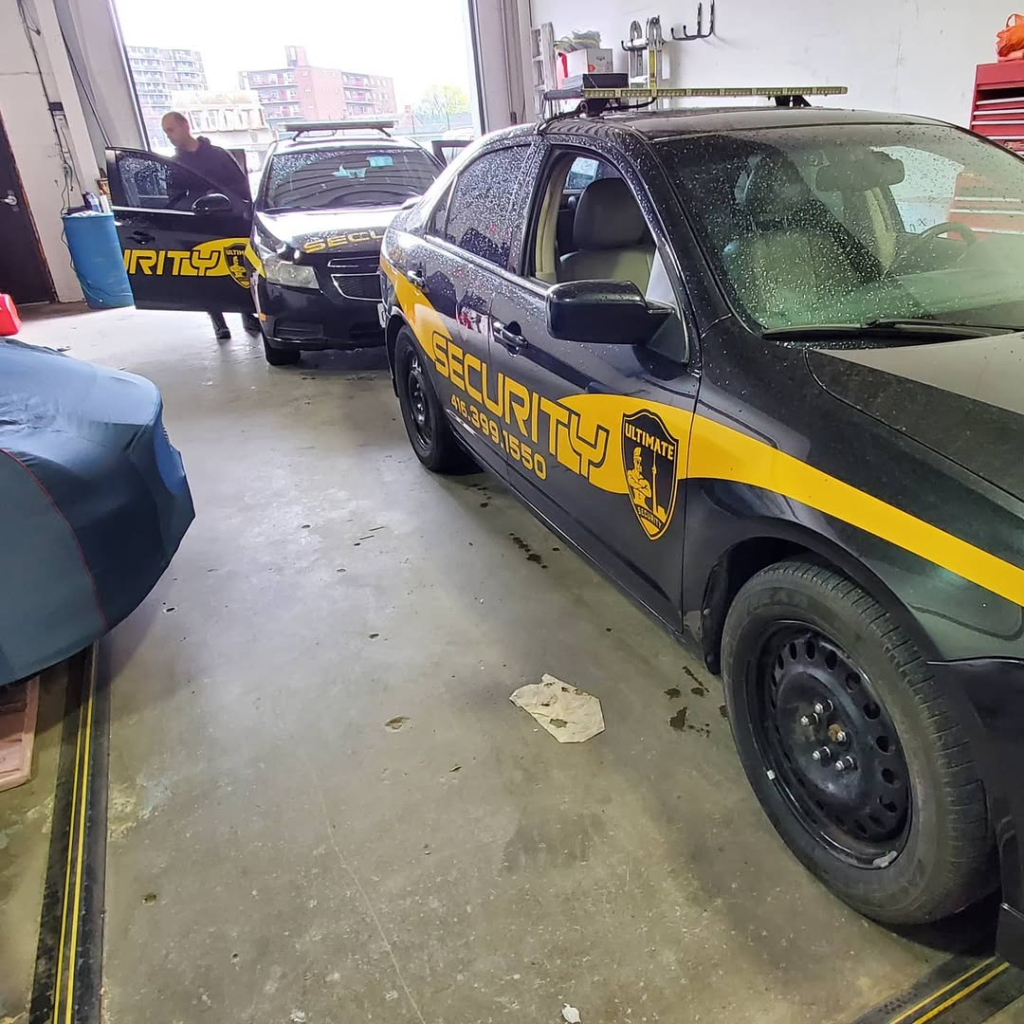 image 15 Two black and yellow security vehicles are parked inside a garage; a person stands near one car's open door in the background. Why should you consider mobile patrol security in Toronto and the GTA for enhanced protection and peace of mind?.